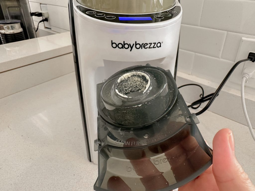 Baby Brezza Formula Pro Formula Dispenser with Formula stuck to it