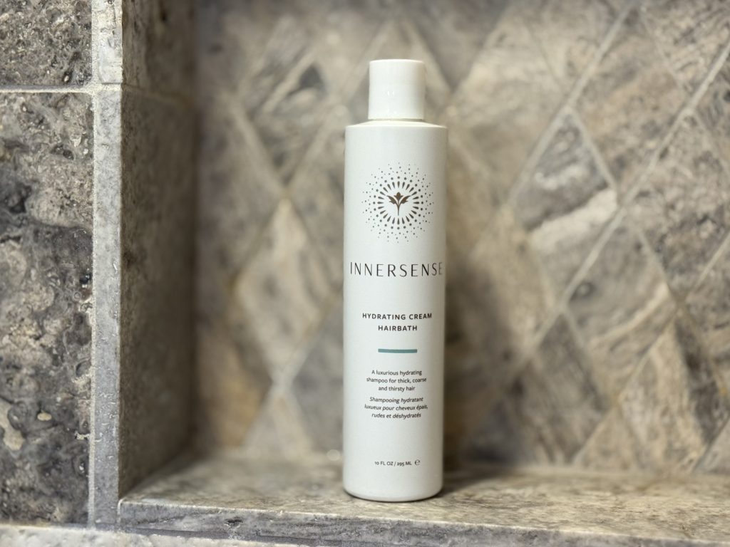 White shampoo bottle against tile background.