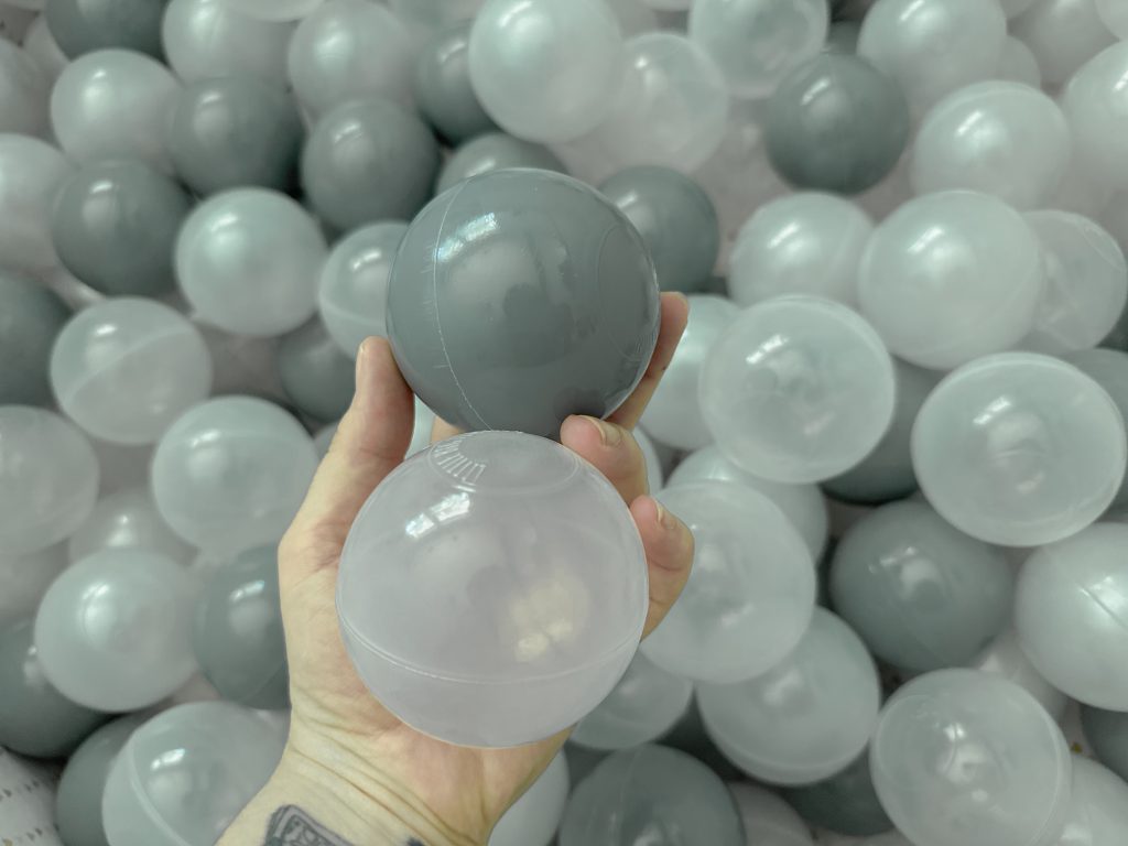 hand holding two plastic balls