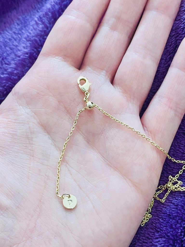 Open hand holding a Pavoi Necklace Chain focused on showing a sliding bead.