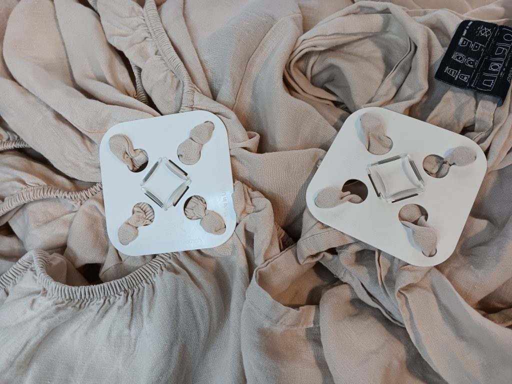A Wad-Free attached to a flat sheet and another attached to a fitted sheet