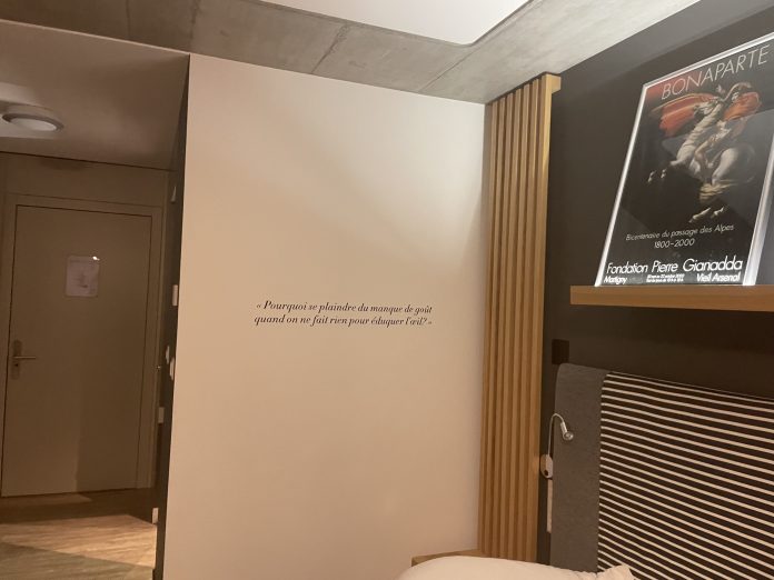 Writing on the wall and paintings above bed at Martigny Boutigue Hotel