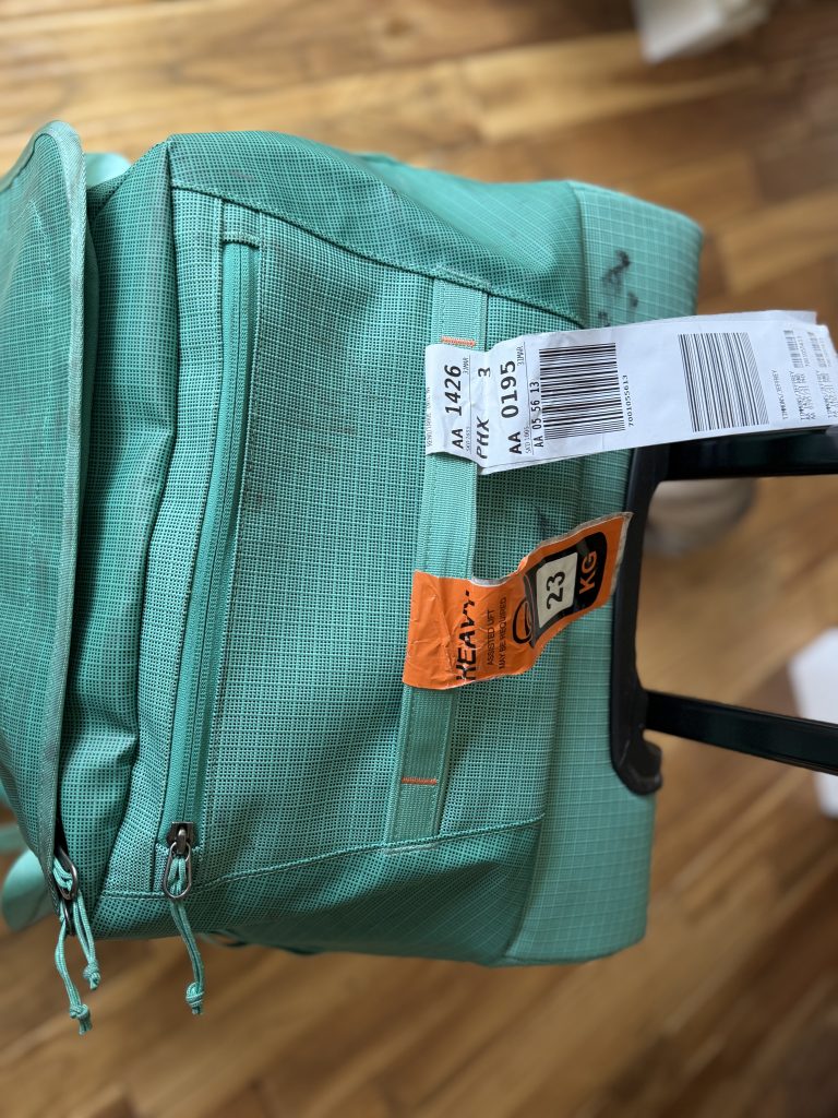 Close up of the top of the Black Hole Wheeled Duffel and its exterior zippered pocket.
