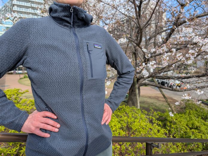 Person wearing the Patagonia R1 Air Fleece in front of a cherry blossom tree.