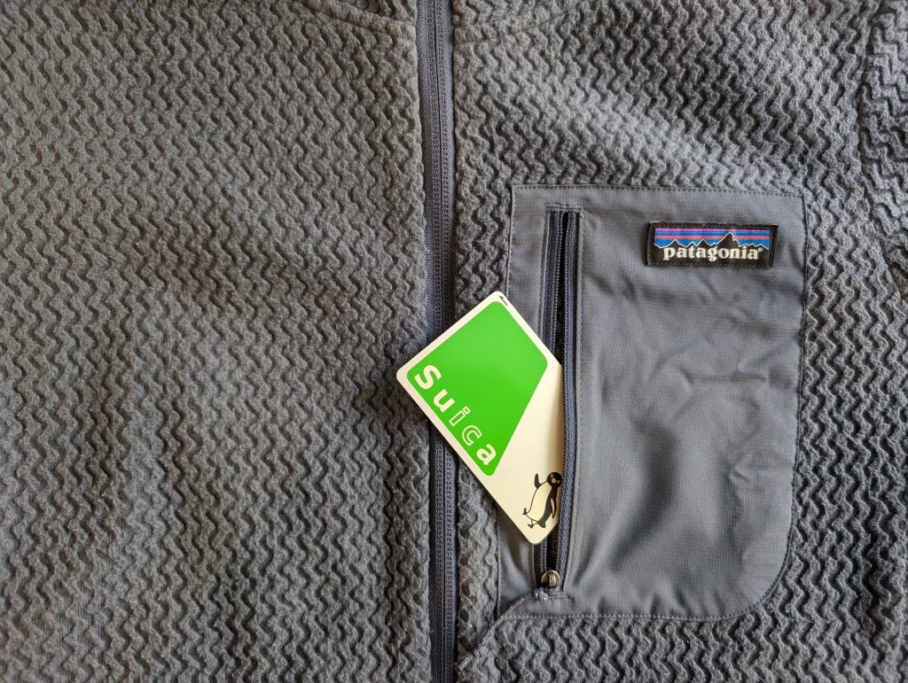 A Suica train card sticks out of the chest pocket on the Patagonia R1 Air fleece